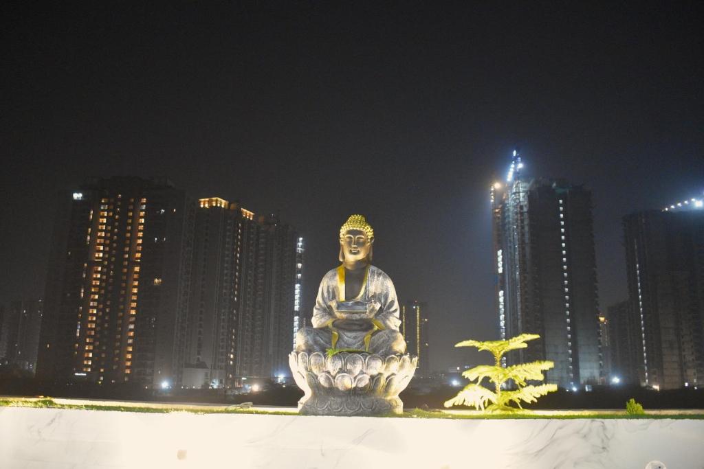 a statue in front of a city at night at Mehi villa in Ghaziabad