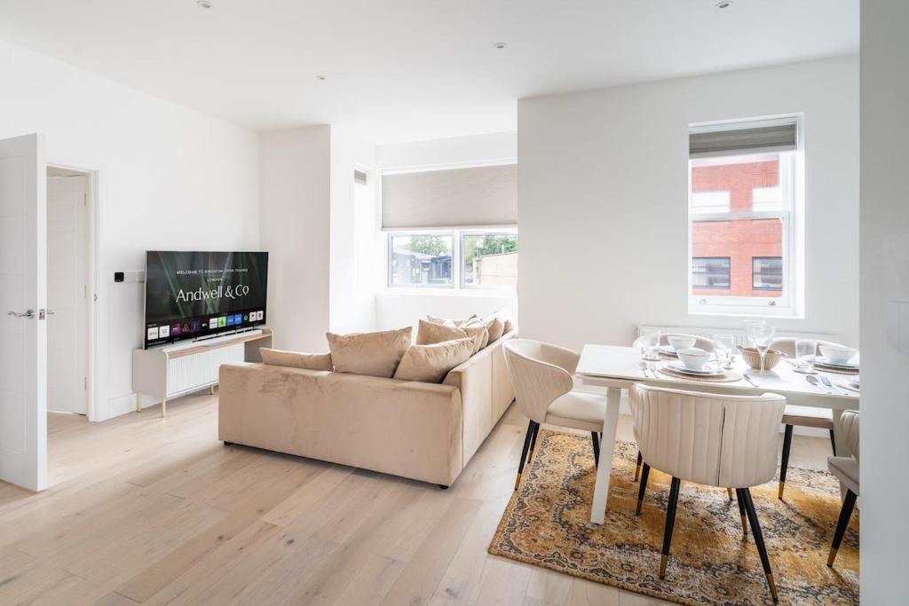 a living room with a couch and a table at Stylish 2BR Flat by Richmond Park in Kingston upon Thames
