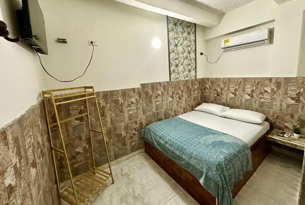 a small bedroom with a bed and a television at LUA origenes Alojamiento FIRST FLOOR in Santa Marta
