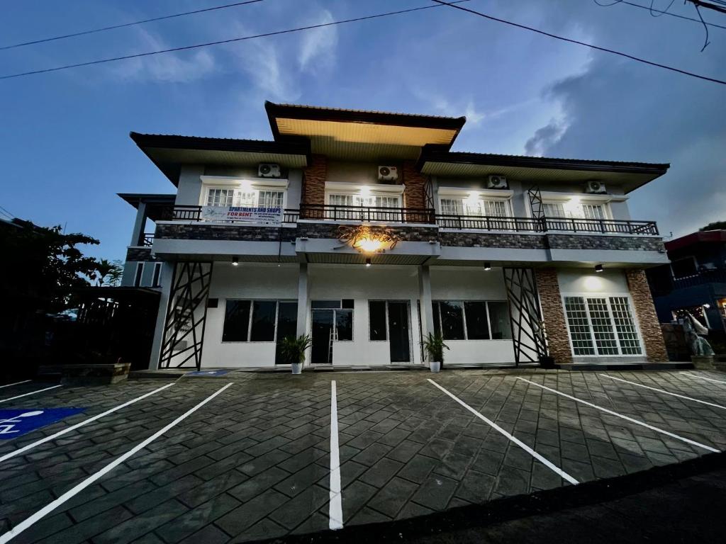 a building with a parking lot in front of it at Balay by JMB in Legazpi