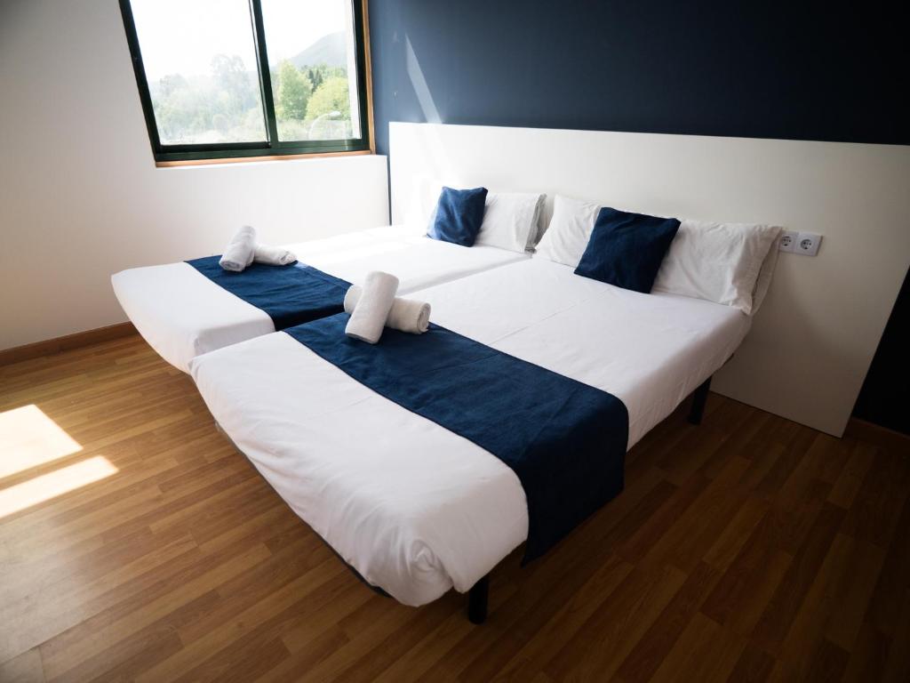 a bedroom with two beds with blue and white sheets at Bahía de San Simón in Redondela