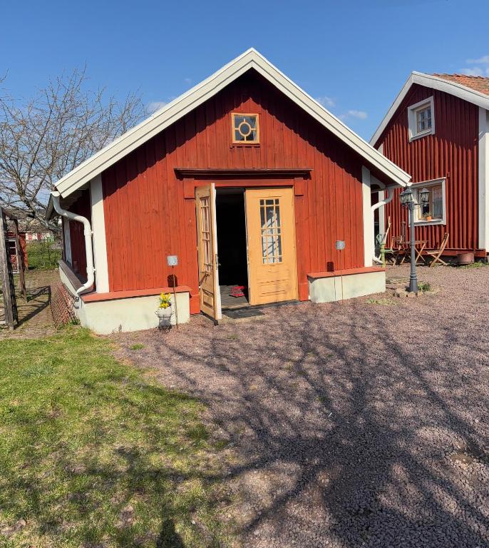 a red barn with a door in a yard at Ateljé Sjögatan in Gränna