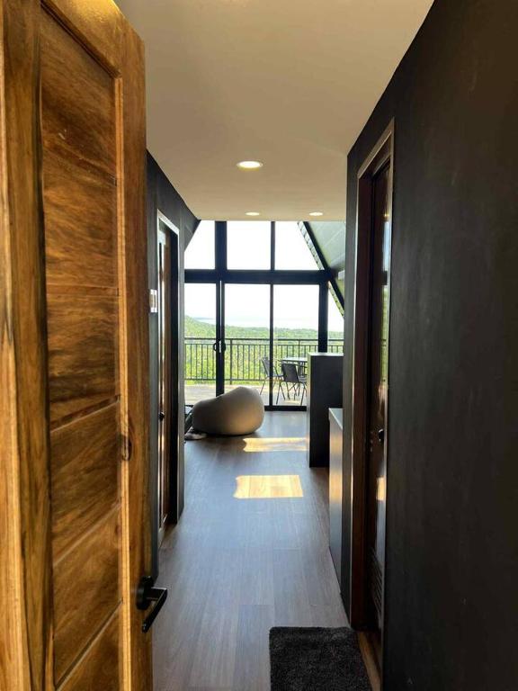 a hallway with a wooden door and a living room at Romantic A-Frame Cabin w/ a View + WiFi in Samal