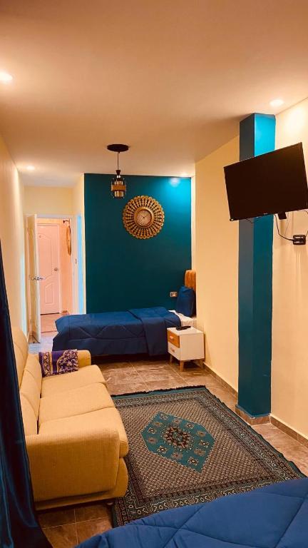a living room with a couch and a blue wall at Ali City Hotel tunis in Tunis