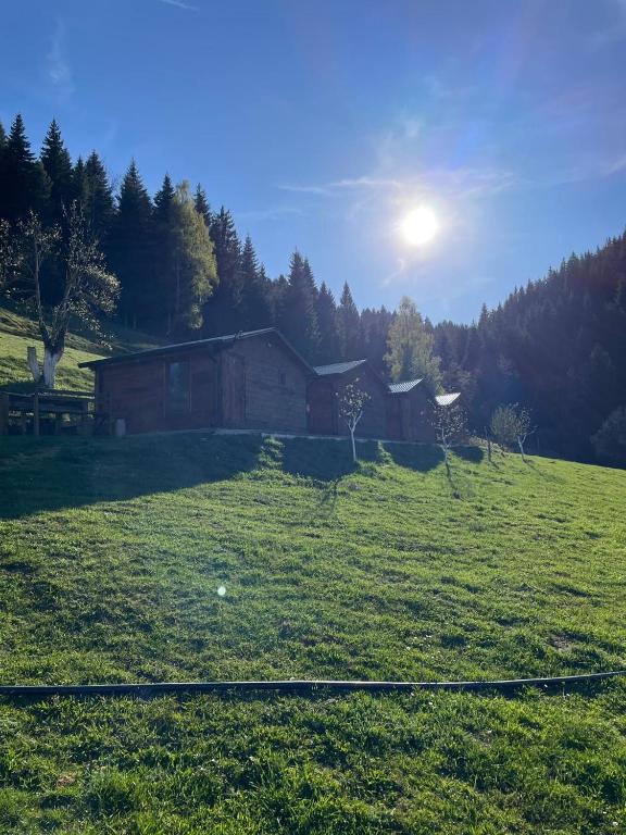 a house in a field with the sun behind it at Bujtina Selimaj in Plav