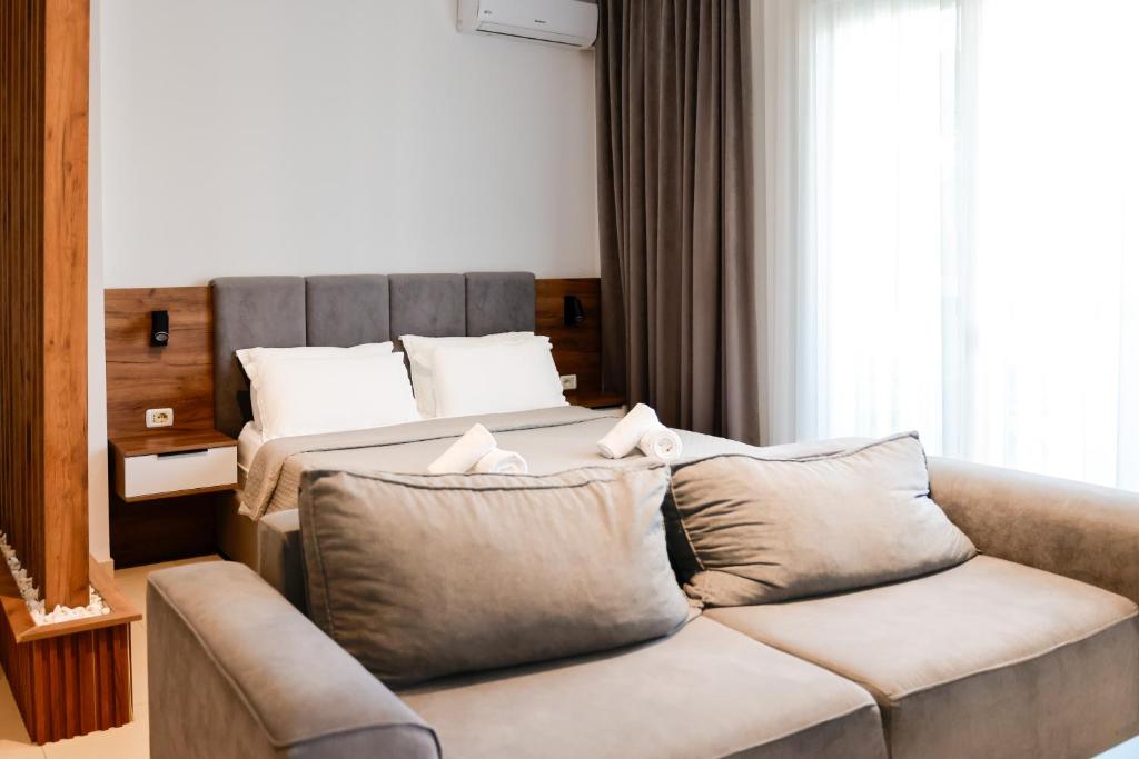 a living room with a couch and a bed at Shkoder City Center Rooms & Apartments in Shkodër