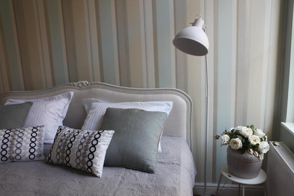 a bedroom with a bed with pillows and a lamp at ZevenVrijeDagen in Ghent