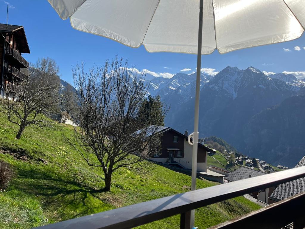 a view of a mountain from a balcony with an umbrella at Studio Heaven in Grächen
