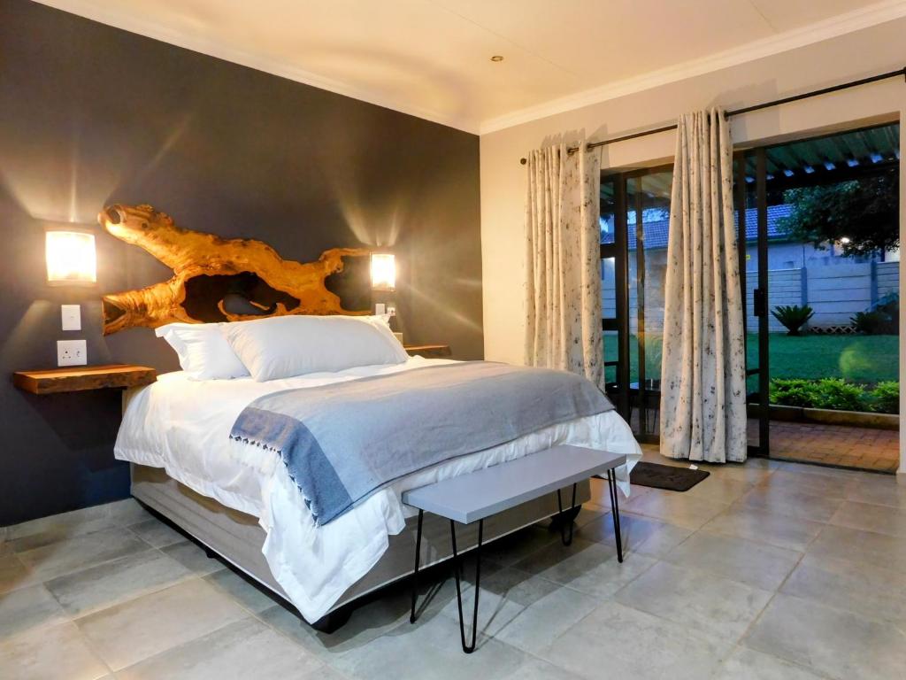 a bedroom with a large bed and a large window at Mountain Manor in Louis Trichardt