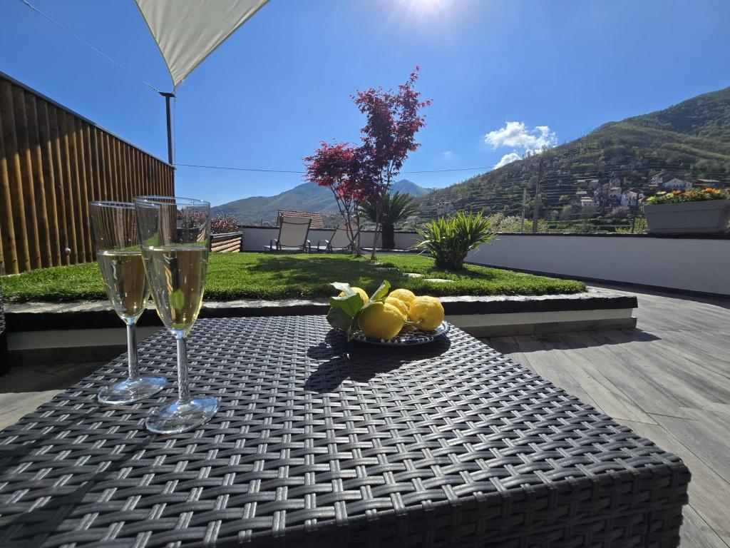 a table with two wine glasses and a bowl of fruit at Casa Mia Holiday House in Pianillo