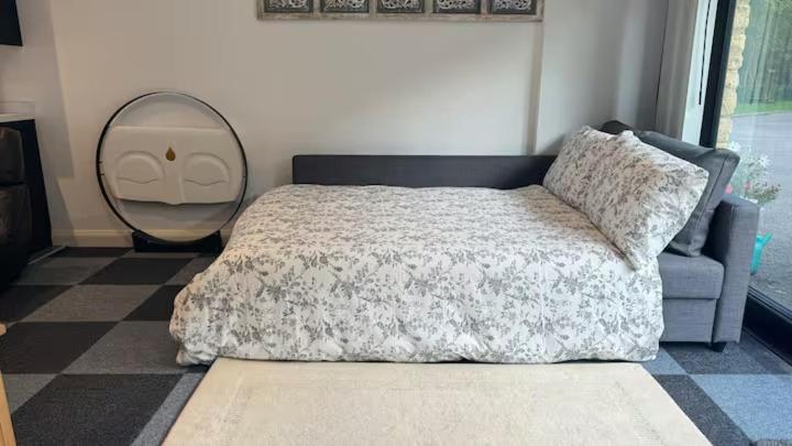 a bedroom with a bed and a mirror and a couch at Four Poster Hideaway in Chacombe