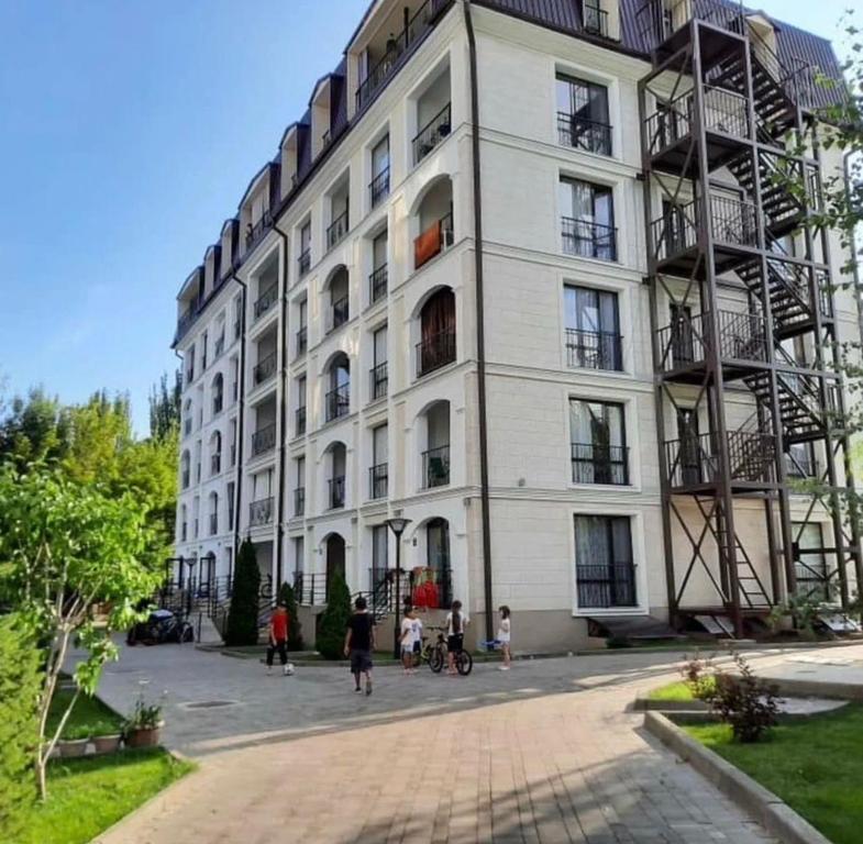 a large white building with people walking in front of it at Радуга in Chon-Sary-Oy