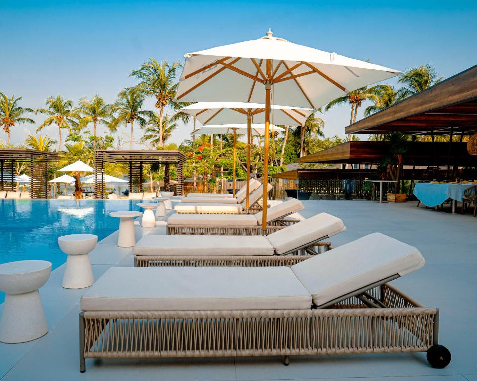 a group of lounge chairs and an umbrella next to a pool at BBr in Jacqueville