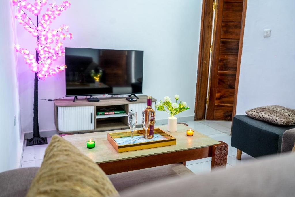 a living room with a table and a tv at Assinie's apartment in Assinie