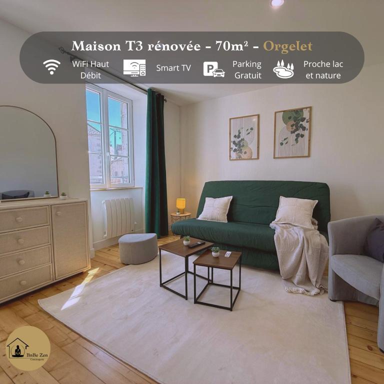 a living room with a green couch and a table at Maison au cœur d’Orgelet in Orgelet