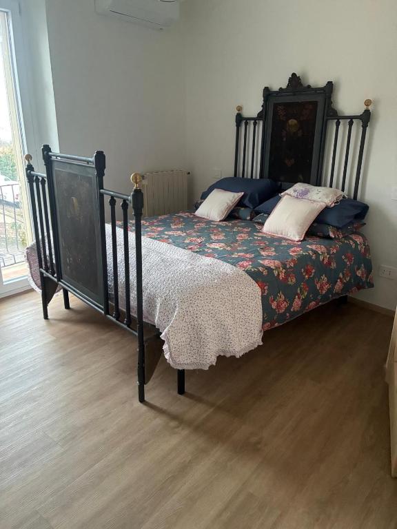 a bedroom with a black bed with a floral bedspread at Sotto la Cupola in Montefiascone
