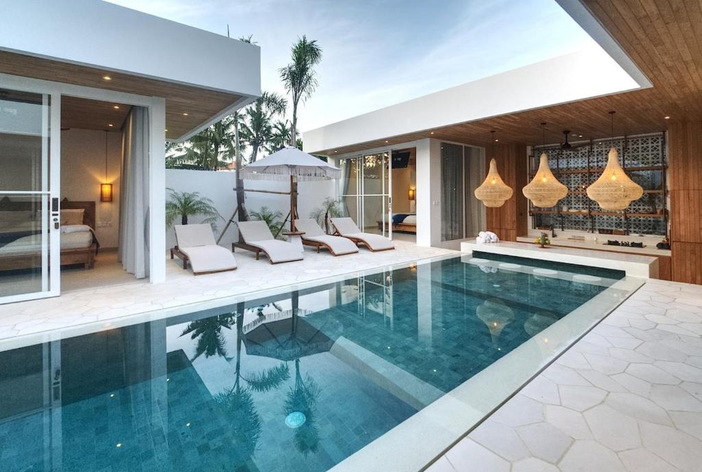 an infinity pool in a villa with a bedroom at The Avlu Modern Spa Retreat in Tanah Lot