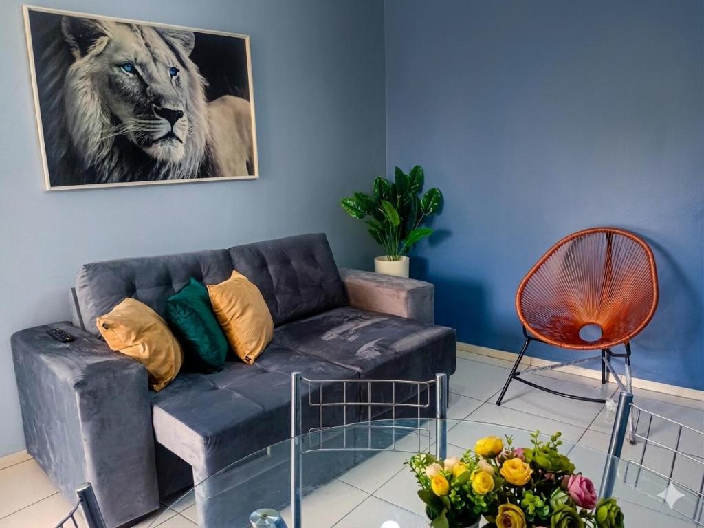a living room with a couch and a lion picture at Refúgio no Centro in Imperatriz