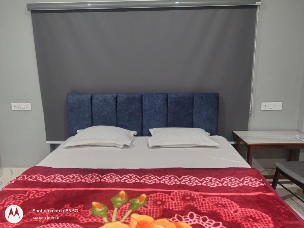 a bed with a blue headboard in a room at Chouhan Resort in Katihār