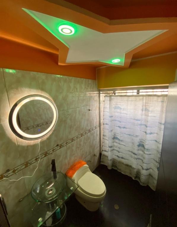 a bathroom with a toilet and a sink and a mirror at Casa Cristian in Caracas