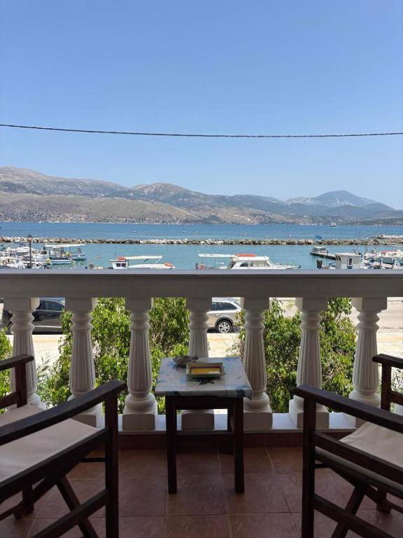 a balcony with chairs and a view of a harbor at Karyatis studios lixouri in Lixouri