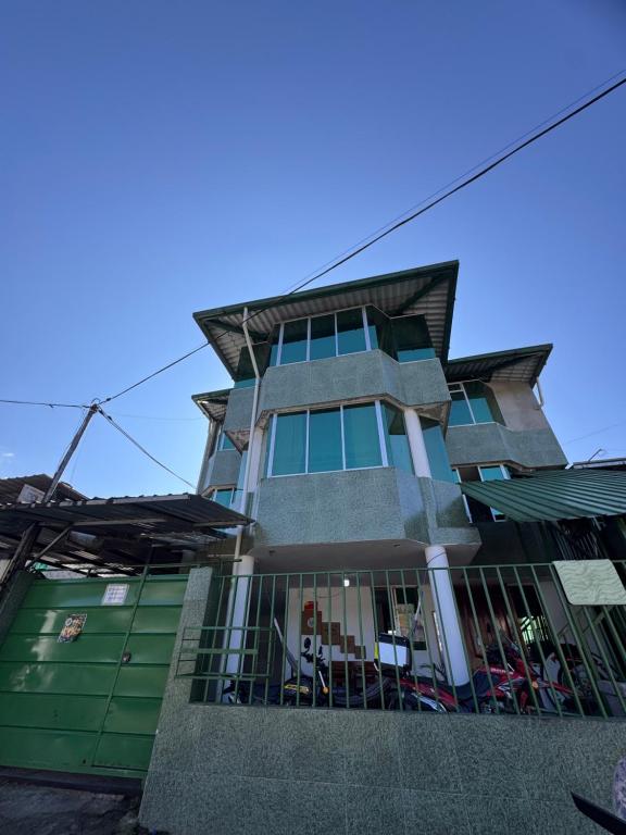 a tall building with green and gray at Hostal El Viajero-Mindo in Mindo