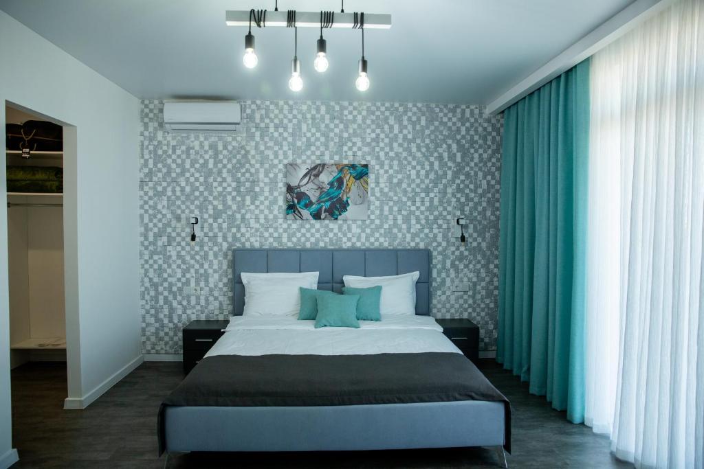 a bedroom with a bed with blue and white wallpaper at Sunday Caprice in Sanzhiyka
