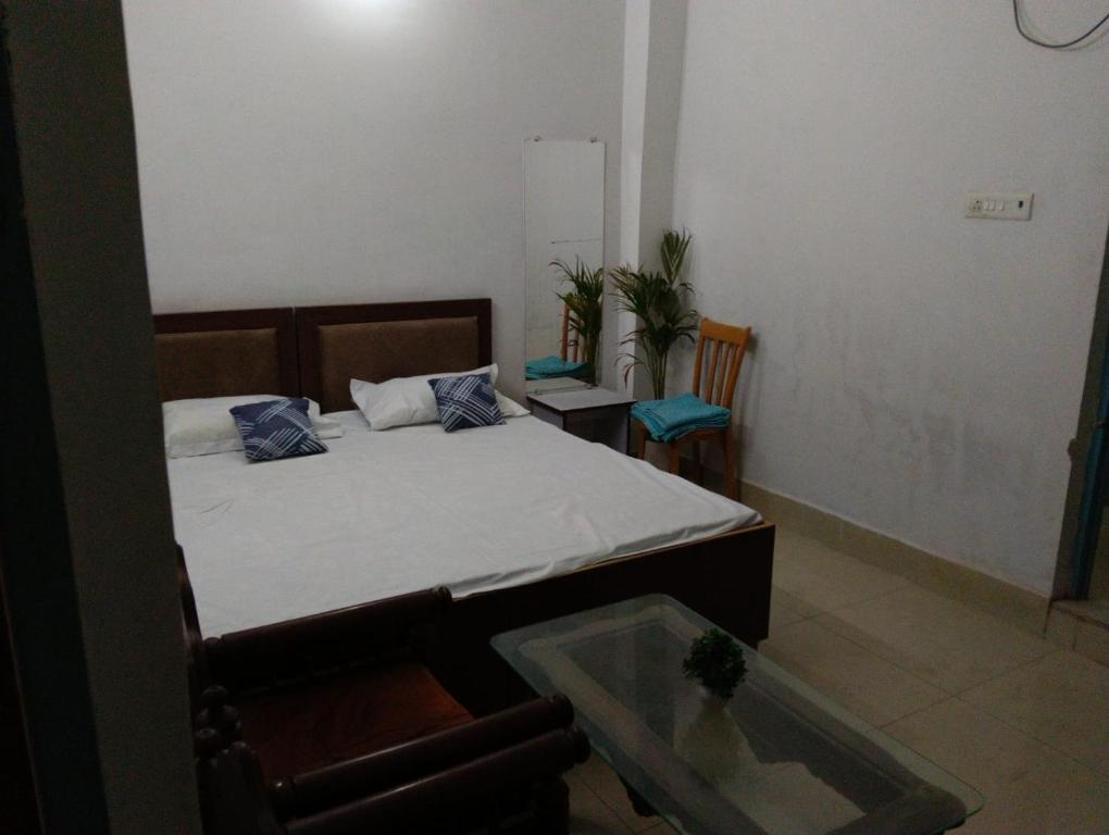 a small bedroom with a bed and a glass table at Hotel Vasu in Gopālganj