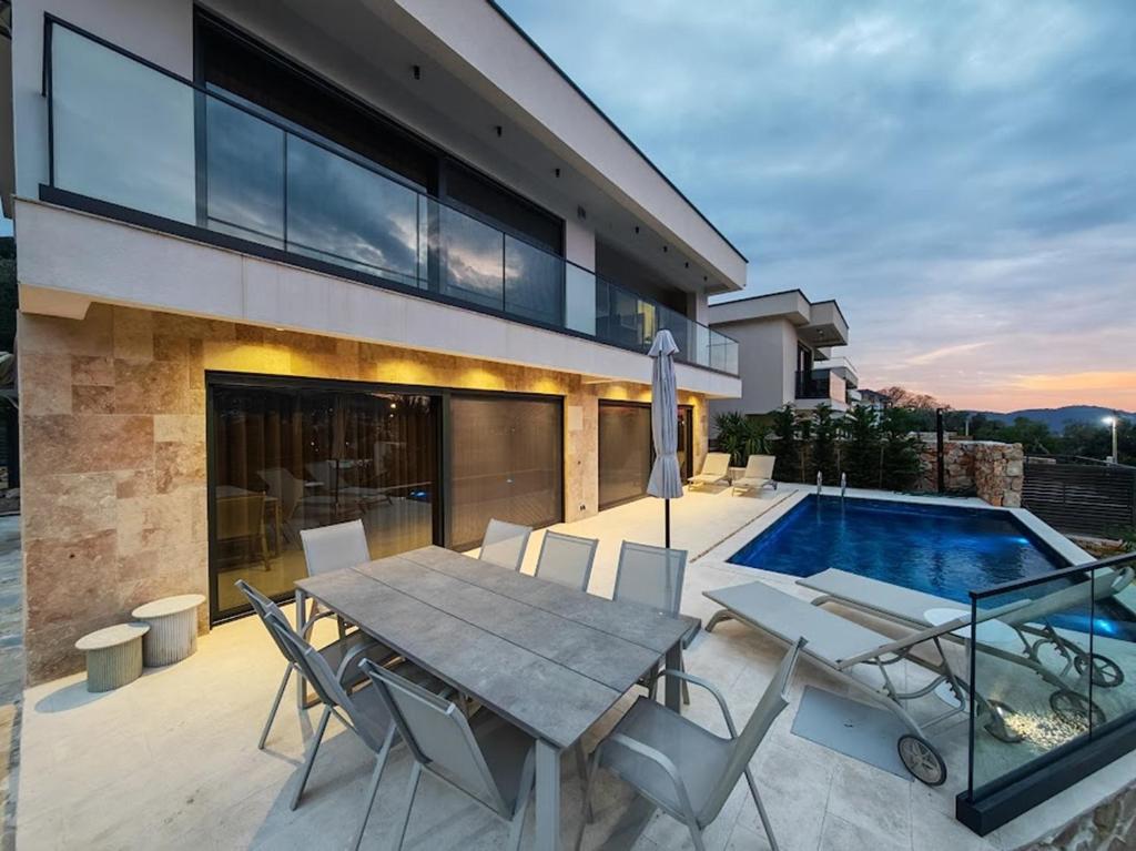a patio with a table and chairs next to a swimming pool at Villa Bartula in Bar