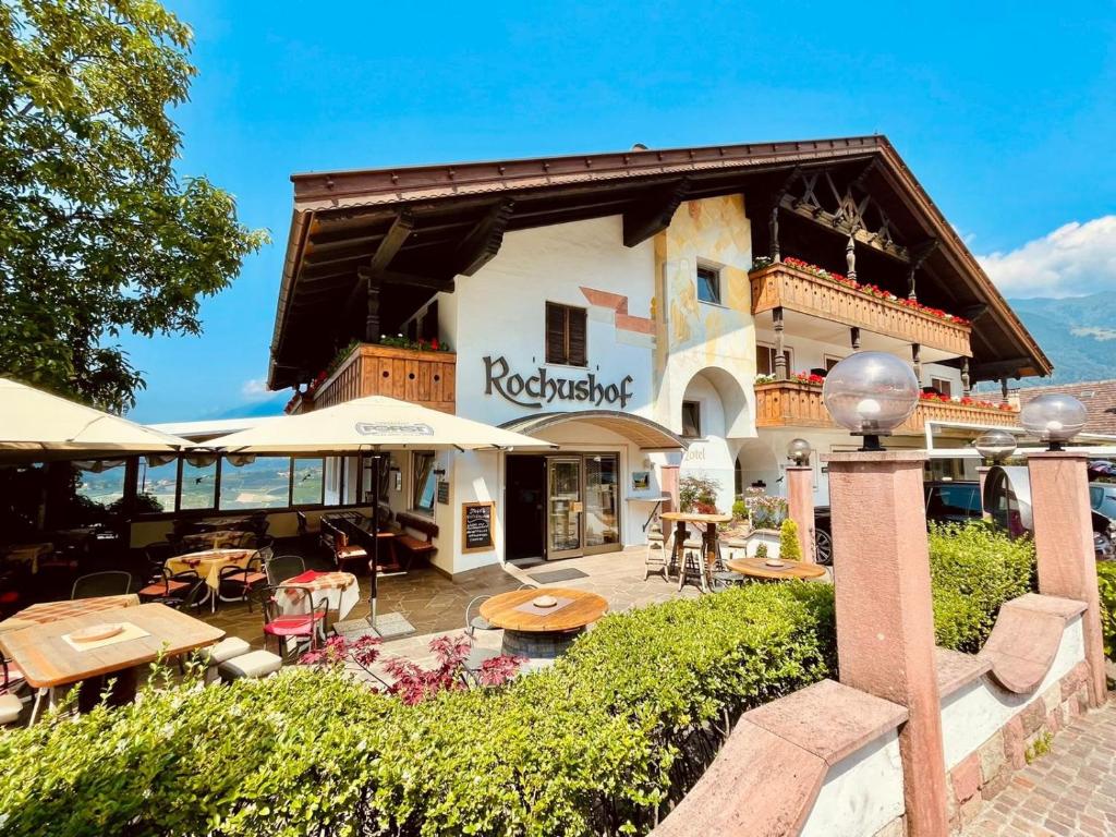 a building with tables and chairs in front of it at Hotel Rochushof in Schenna