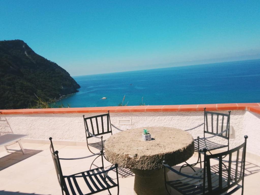 a table and chairs with a view of the ocean at Riflessi della baia in Forio d'Ischia