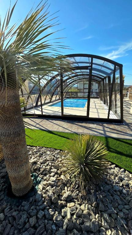 a palm tree and a building with a swimming pool at ApartPodhale in Raba Wyżna