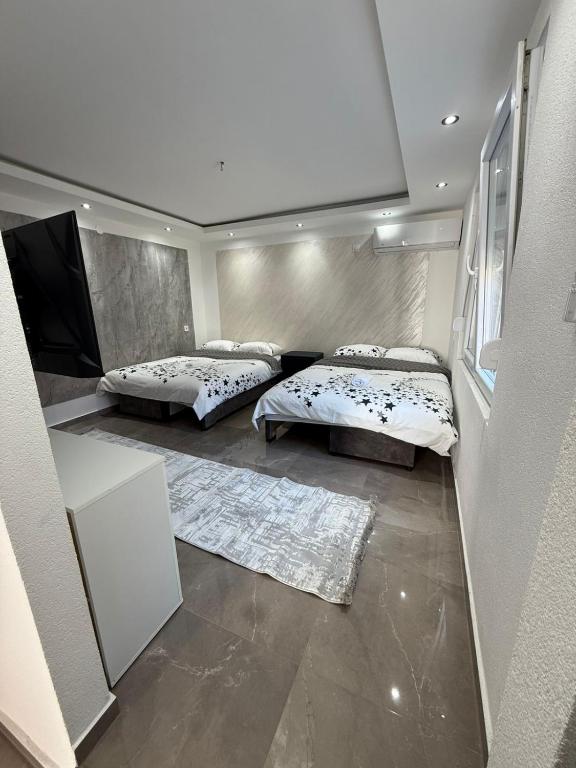 a bedroom with two beds and a flat screen tv at Stan na dan Berane in Berane