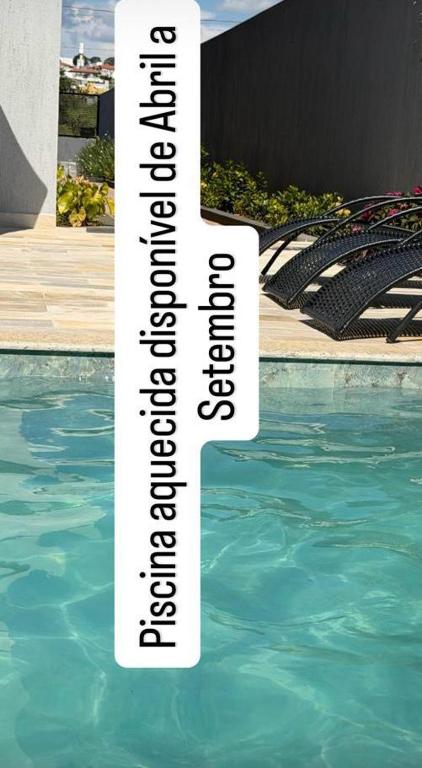 a sign in the water next to a swimming pool at FLATs UTOPIA in Capitólio