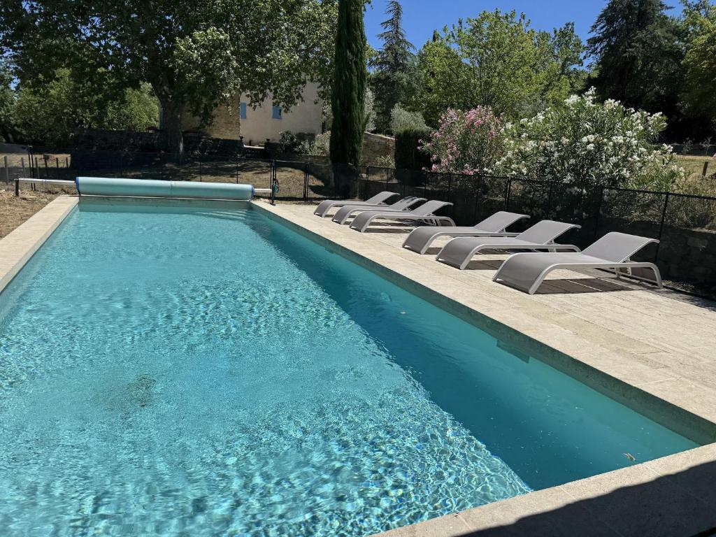 a swimming pool with lounge chairs and a swimming pool at Villa in Saignon with Pool and Scenic Views in Ménerbes