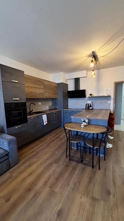 a living room with a table and a kitchen at Riverside Vrchlabí in Vrchlabí
