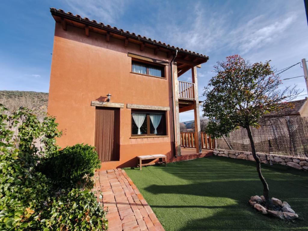 a house with a green lawn in front of it at Casa Puerta de Albarracín in Albarracín