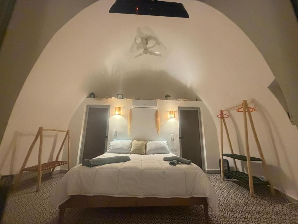 a bedroom with a white bed with a ceiling at Lodgegarden in Aït Bounnit