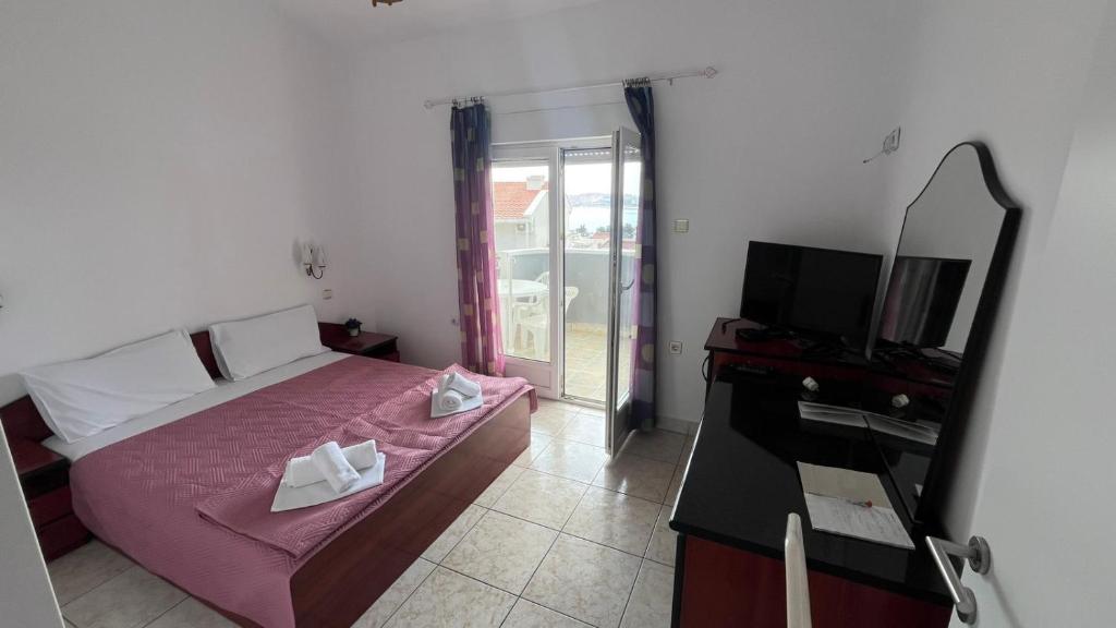 a bedroom with a bed and a mirror and a television at Konak Vukojević in Šušanj