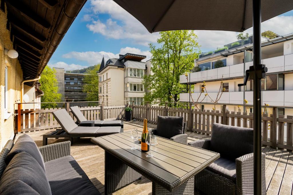 a patio with a table and chairs and an umbrella at Maisonette-Apartment mit großer Terrasse im Zentrum von Bregenz in Bregenz
