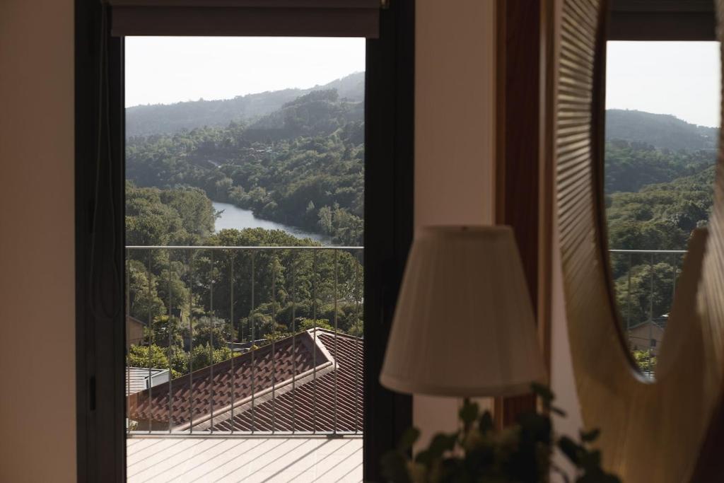 a room with a window with a view of a mountain at Casa do Formão in Amarante