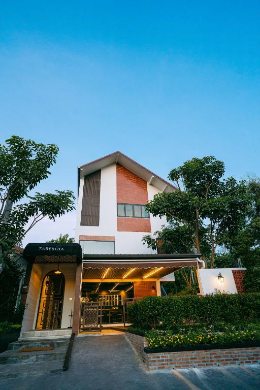 a building with a restaurant in front of it at Tabebuia House ทาเบบูย่าเฮ้าส์ in Pathiu