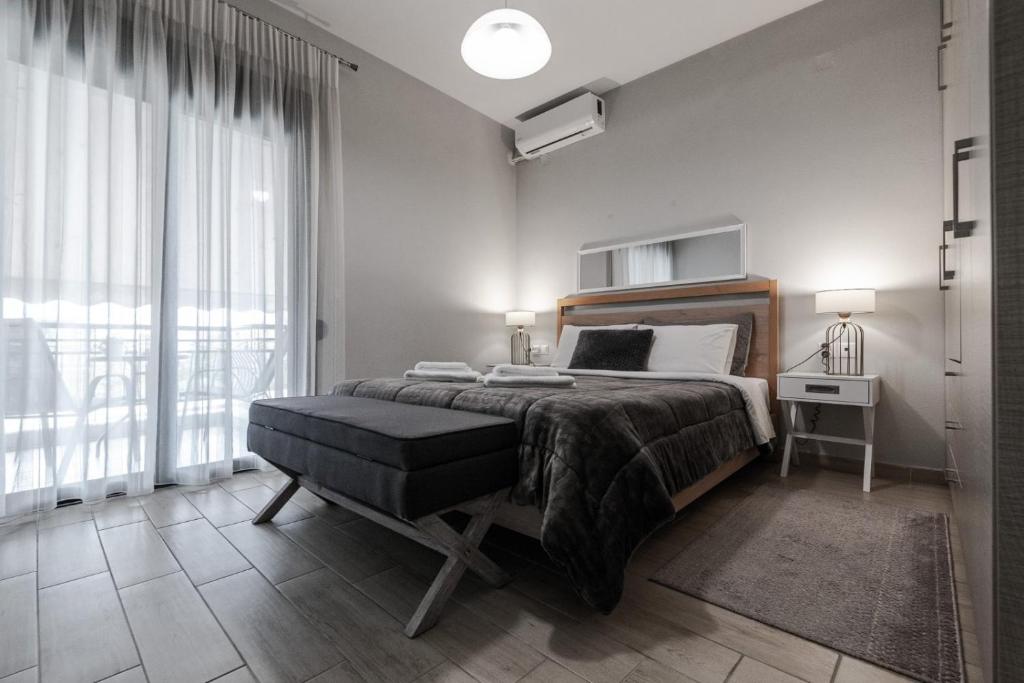 a bedroom with a bed and a large window at Volos Comfort Stay with free parking in Volos