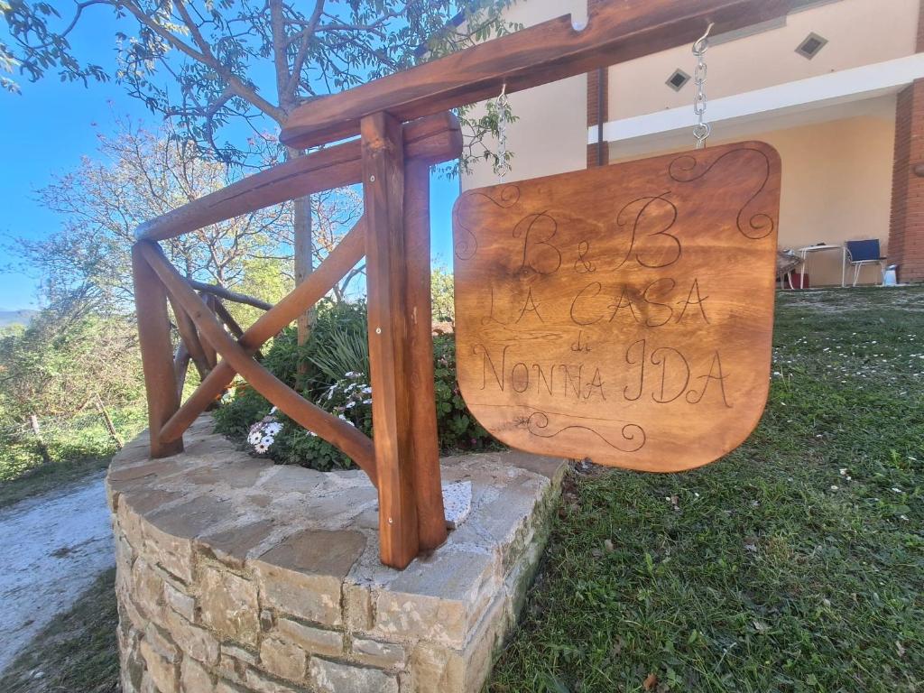 a wooden sign on top of a stone wall at Dalla Nonna Ida, Casa Vacanze con Vista in Toscana in Sestino