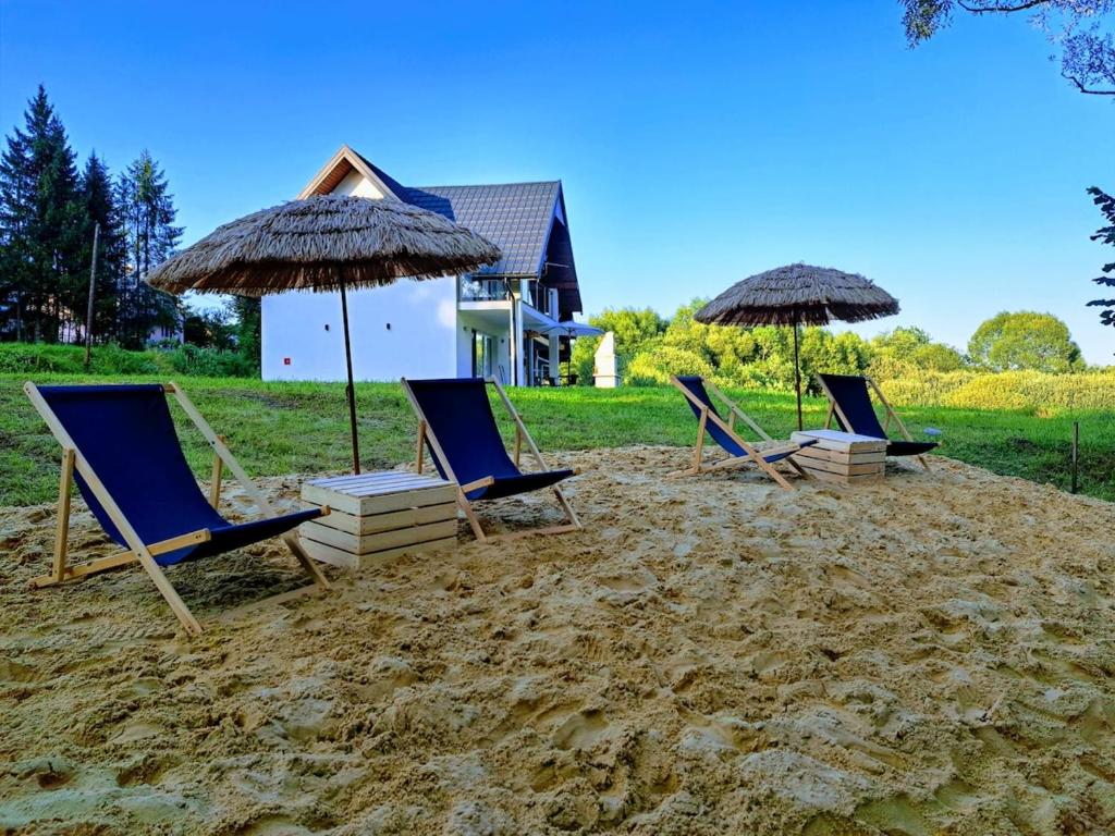 a group of chairs and umbrellas on a beach at U Znajomych in Wołkowyja