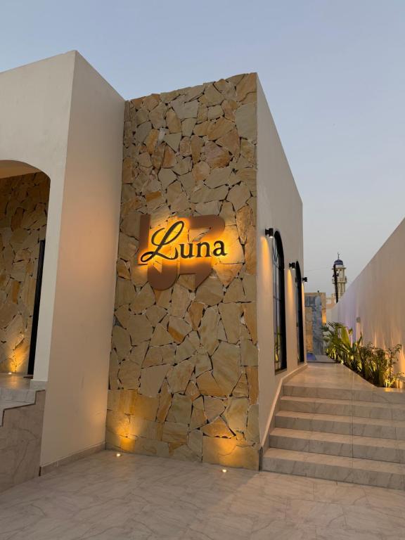 a sign for a jumeirah hotel on a stone wall at Lava & Luna chalets in Sohar