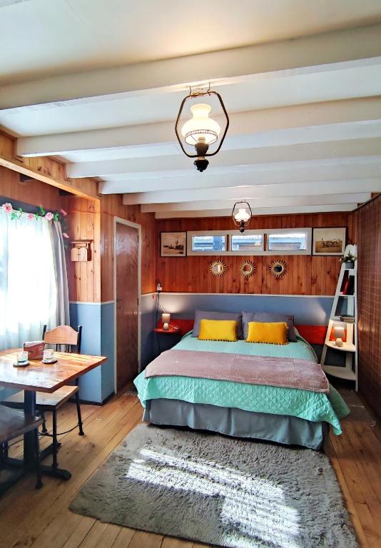a bedroom with a bed and a desk and a table at Victoria Cabin in Victoria