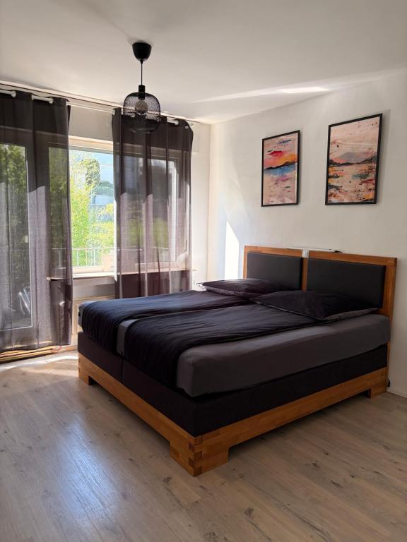 a bedroom with a large bed in front of a window at City-Apartment Leimbach in Siegen