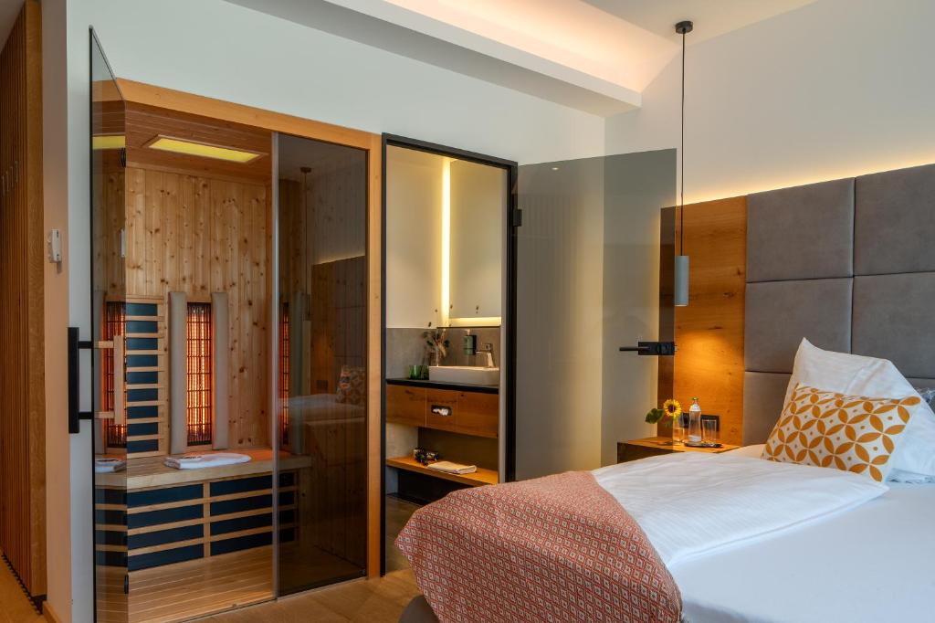 a bedroom with a bed with a glass wall at Patrix Hotel, Restaurant, Bar in Frankenburg