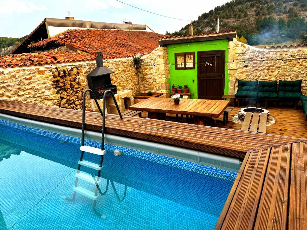 a swimming pool with a ladder next to a house at El nido del Mirlo in Casarejos
